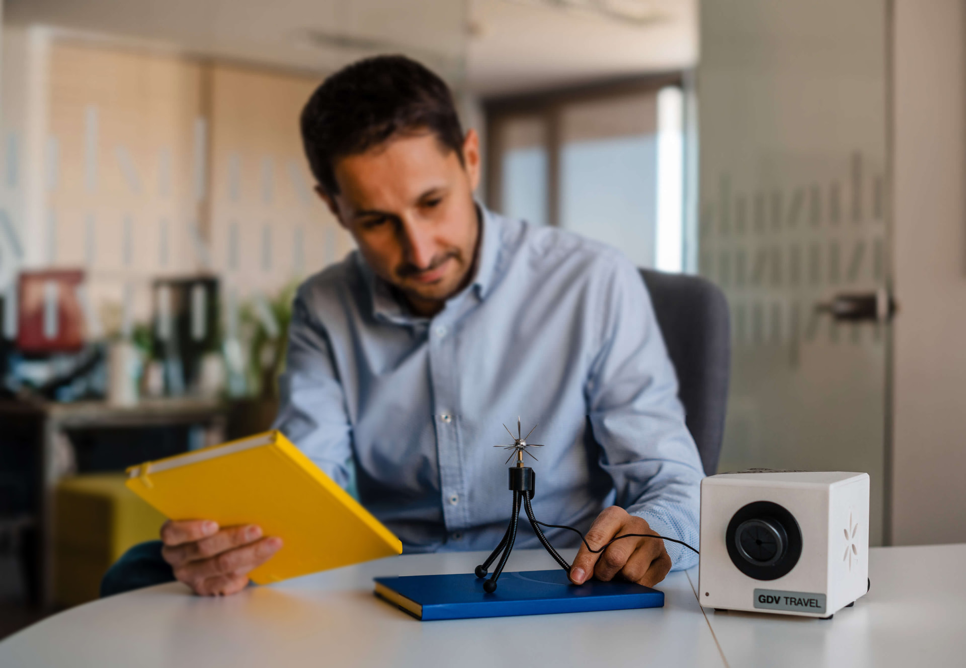 Researcher reviewing notes beside a Kirlian imaging device in an office